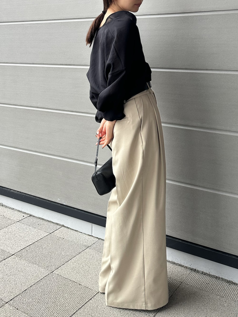 ベージュ系のスラックス、ブラック系のシャツ/ブラウス、ブラック系のスリッポンを着用したレディースの春コーディネートの4枚目の写真