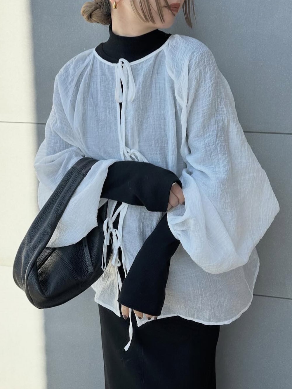 ホワイト系のシャツ/ブラウス、ブラック系のワンピース、ブラック系のスリッポンを着用したレディースの春コーディネートの3枚目の写真