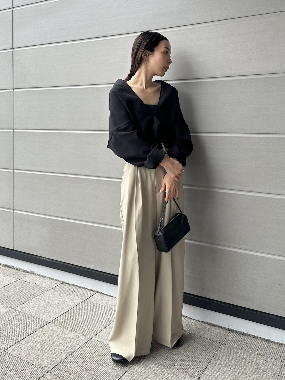 ベージュ系のスラックス、ブラック系のシャツ/ブラウス、ブラック系のスリッポンを着用したレディースの春コーディネートの5枚目の写真