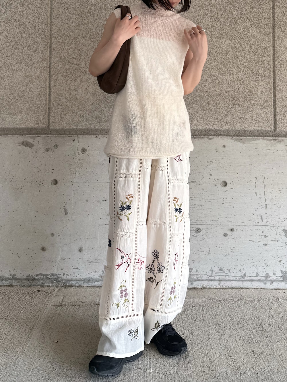 ホワイト系のニット/セーター、ホワイト系のその他パンツ、ブラウン系のハンドバッグを着用したレディースの春コーディネートの5枚目の写真