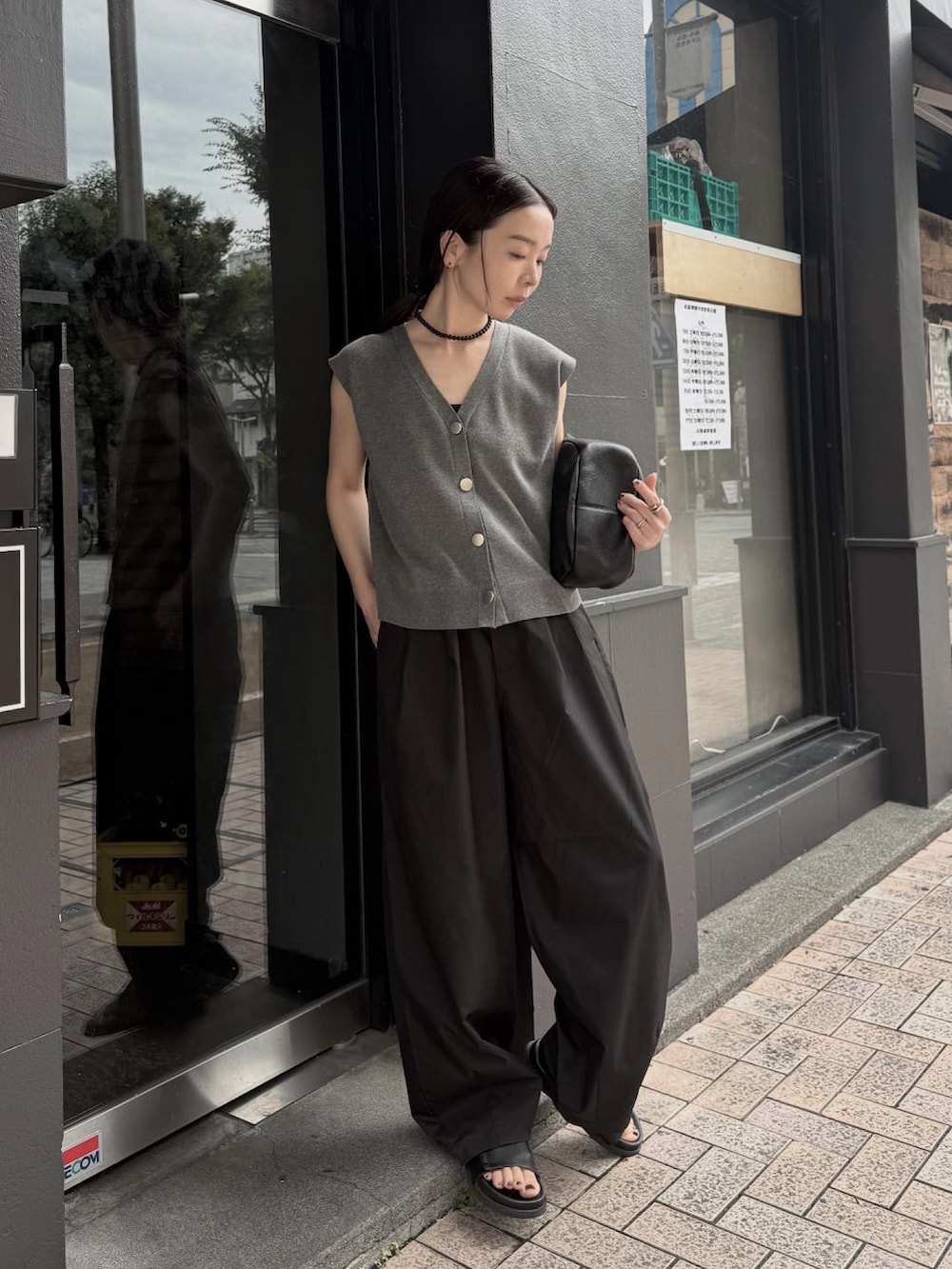 グレー系のベスト、ブラック系のその他パンツ、ブラック系のネックレスを着用したレディースの夏コーディネートの3枚目の写真
