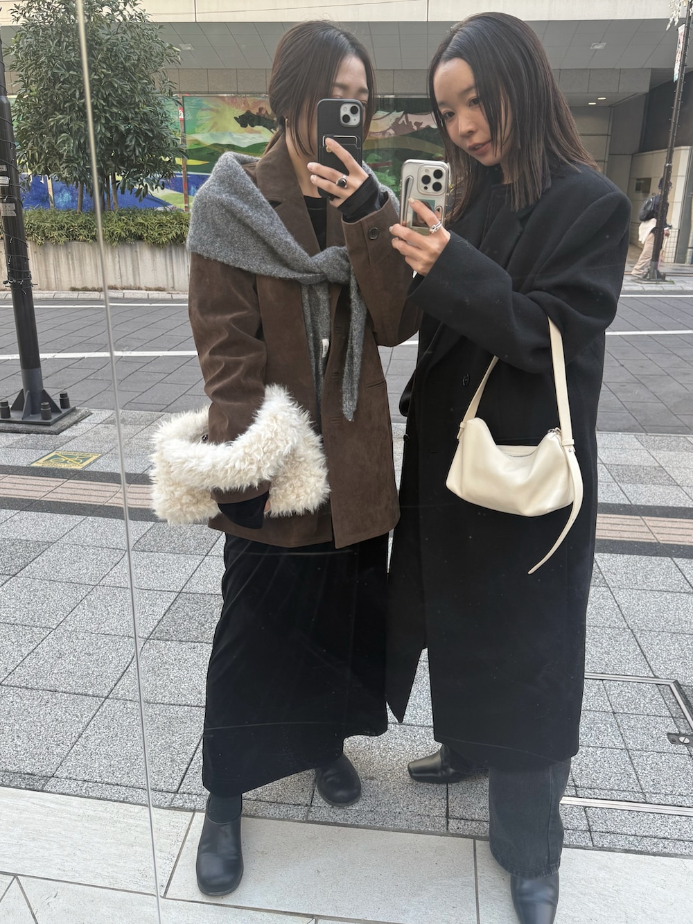 ブラック系のステンカラーコート、ブラック系のニット/セーター、ブラック系のデニムパンツを着用したレディースの秋コーディネートの3枚目の写真