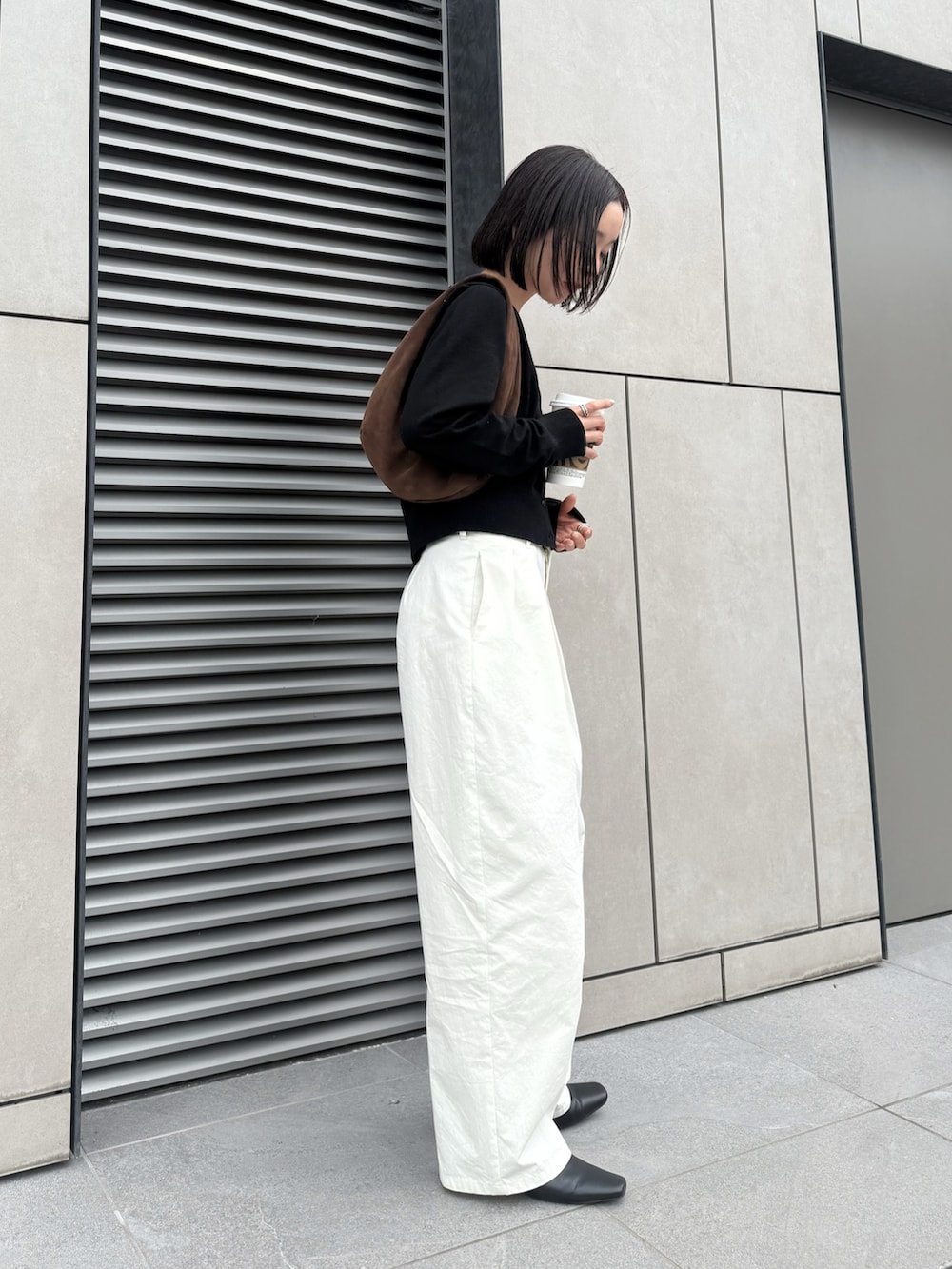 ブラック系のTシャツ/カットソー、ホワイト系のその他パンツ、ブラウン系のハンドバッグを着用したレディースの春コーディネートの5枚目の写真