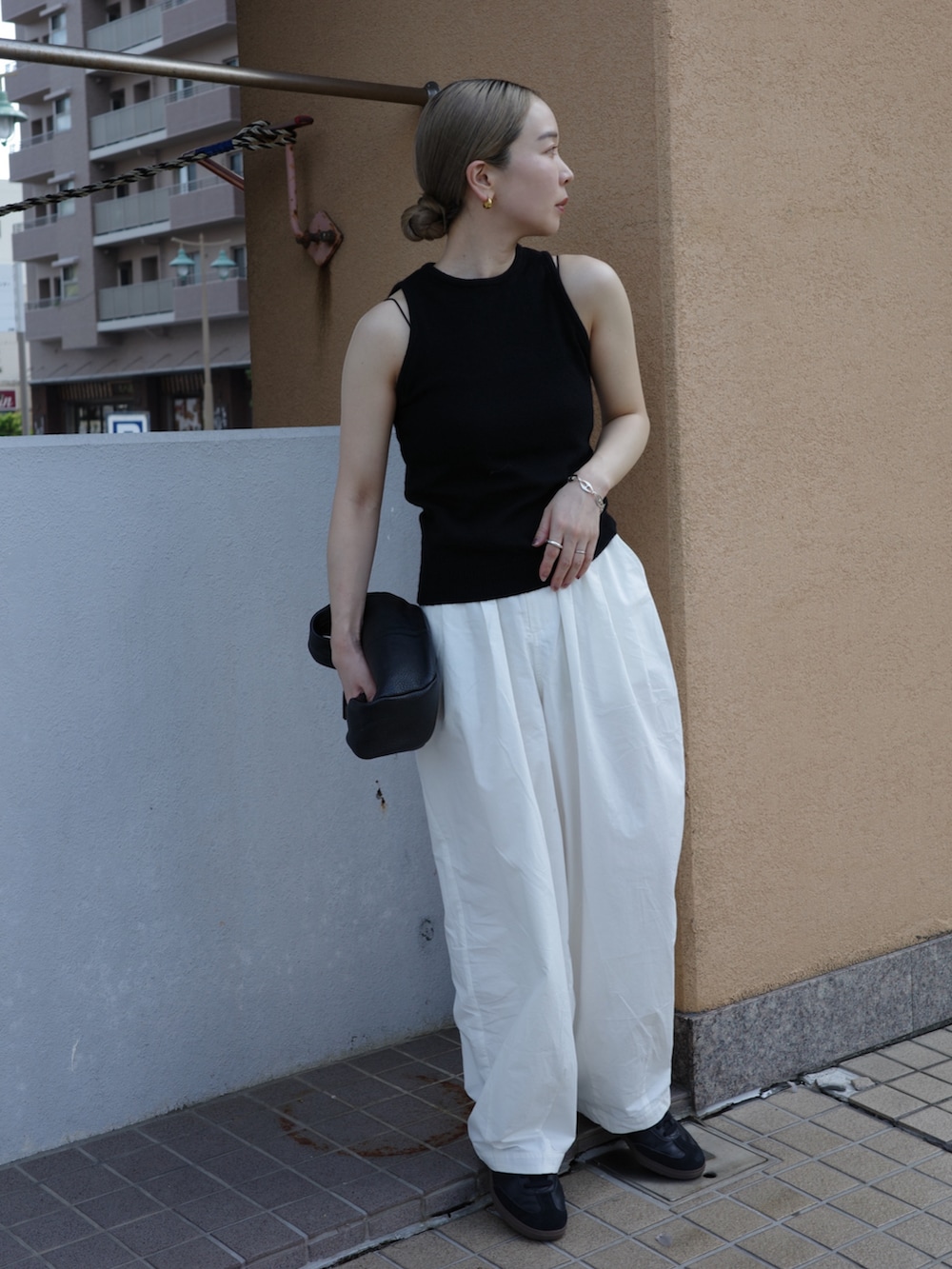 ブラック系のニット/セーター、ブラック系のキャミソール、ホワイト系のその他パンツを着用したレディースの夏コーディネートの2枚目の写真