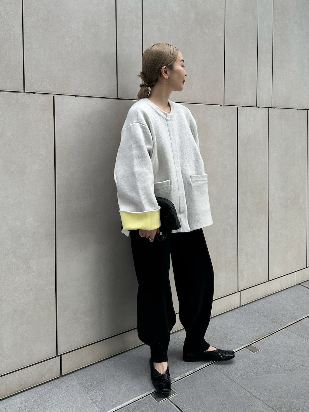 ベージュ系のその他アウター、ブラック系のその他パンツ、ブラック系のハンドバッグを着用したレディースの秋コーディネートの5枚目の写真