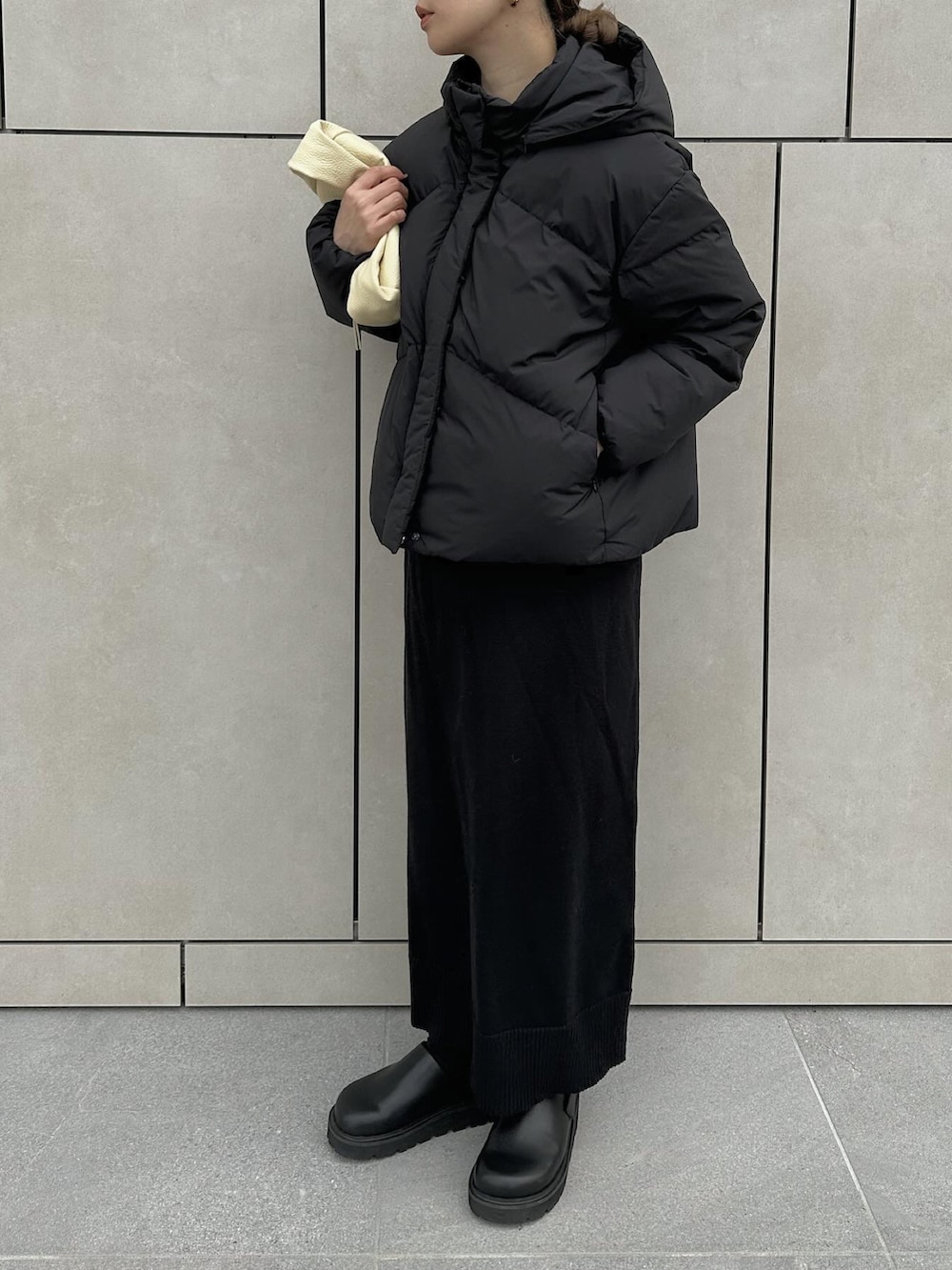 ブラック系のダウンジャケット/コート、ブラック系のスカート、ブラック系のスリッポンを着用したレディースの冬コーディネートの3枚目の写真