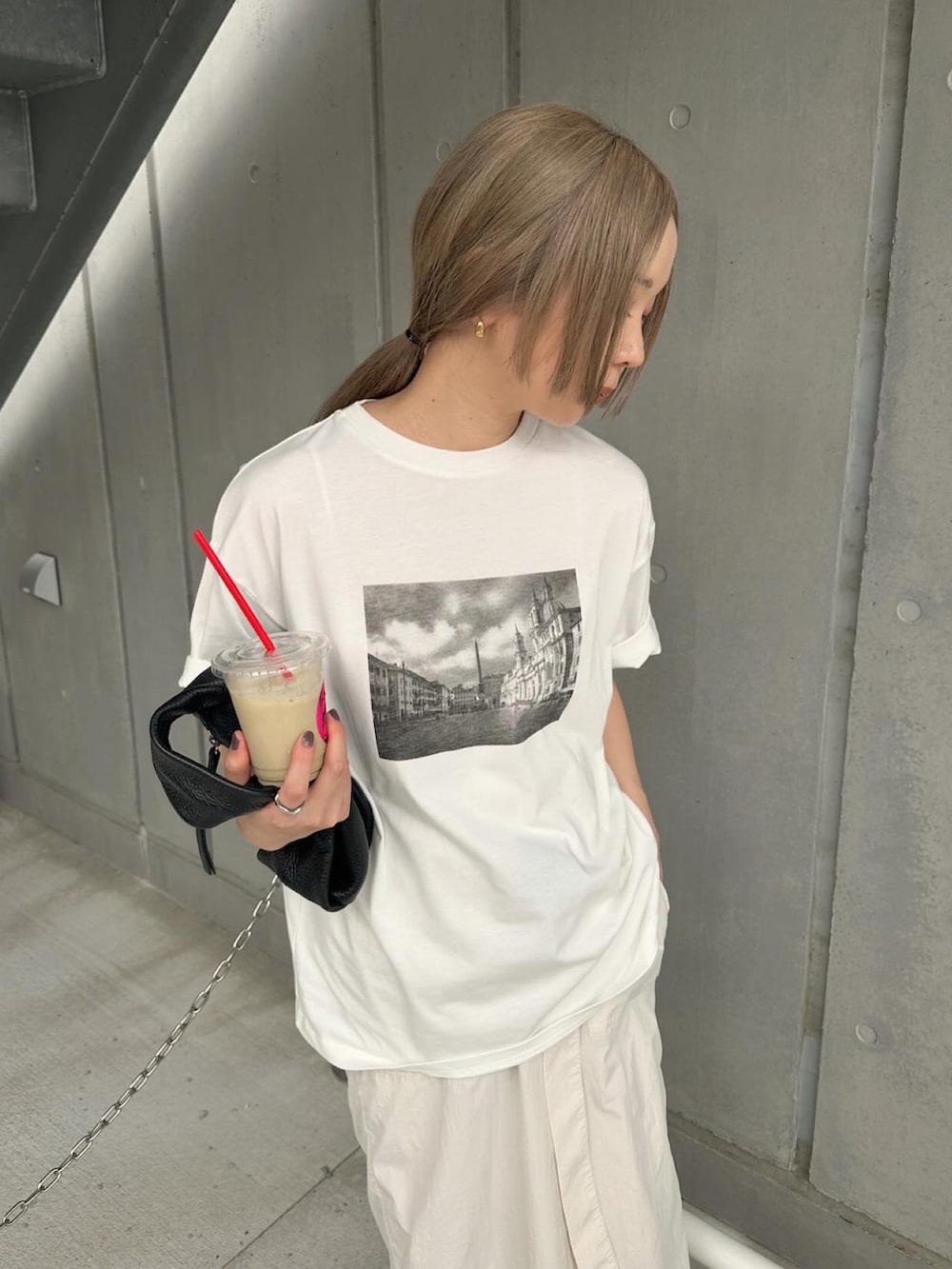 ホワイト系のTシャツ/カットソー、ホワイト系のスカート、ブラック系のスニーカーを着用したレディースの夏コーディネートの4枚目の写真