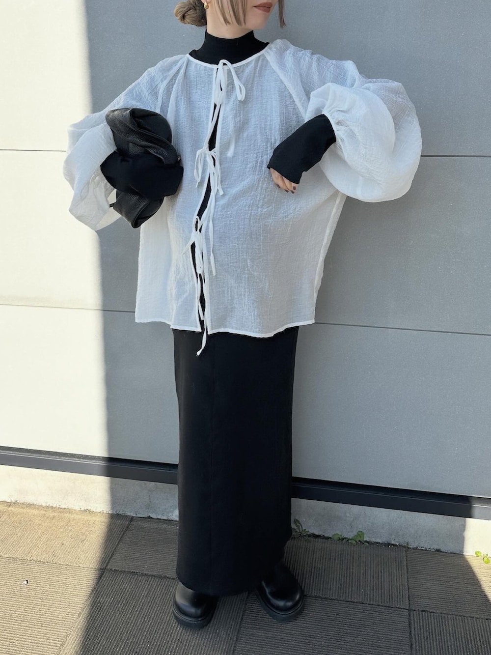 ホワイト系のシャツ/ブラウス、ブラック系のワンピース、ブラック系のスリッポンを着用したレディースの春コーディネートの4枚目の写真