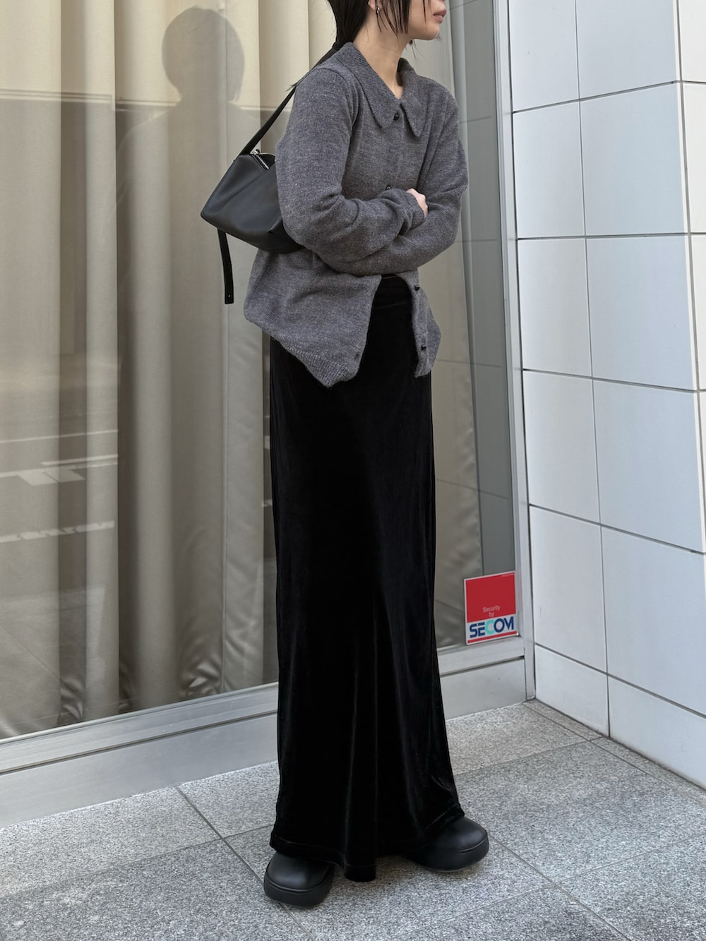 ブラック系のスカート、ブラック系のローファーを着用したレディースの冬コーディネートの4枚目の写真