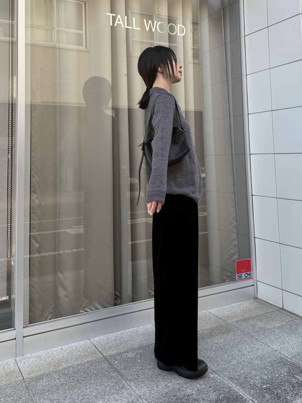 ブラック系のスカート、ブラック系のローファーを着用したレディースの冬コーディネートの3枚目の写真