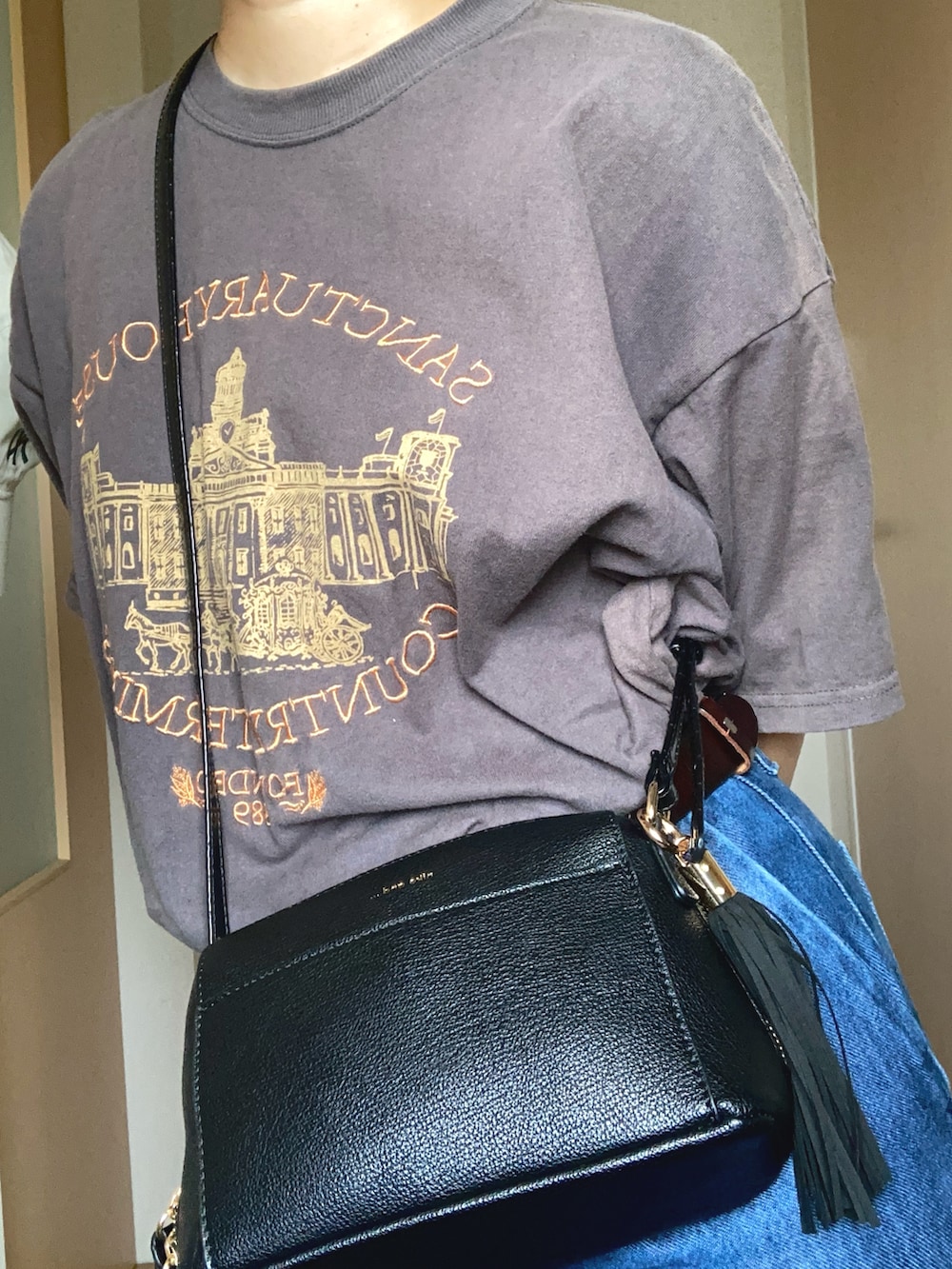 グレー系のTシャツ/カットソー、ブラック系のショルダーバッグ、ブルー系のデニムパンツを着用したレディースの夏コーディネートの2枚目の写真