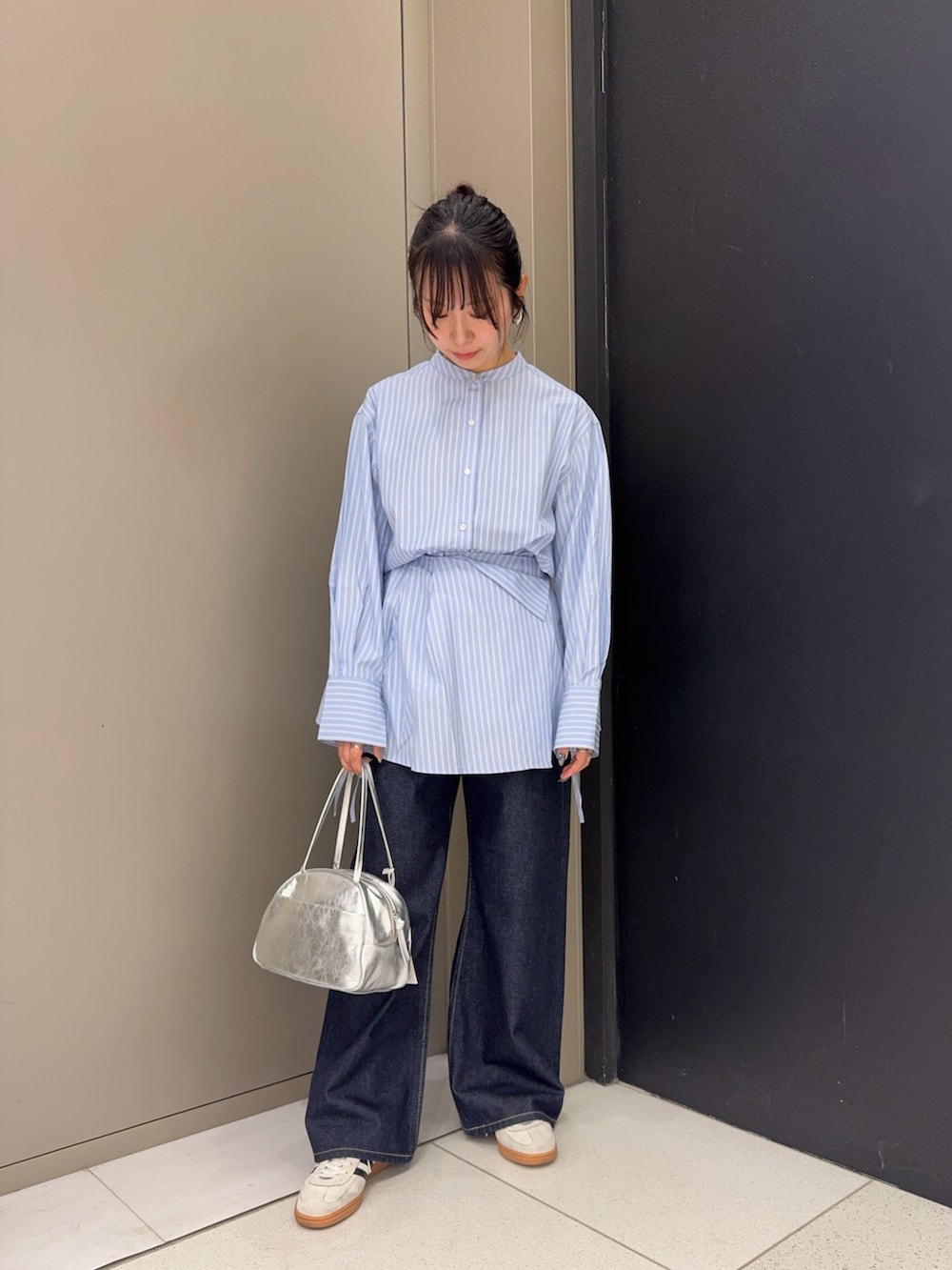 ブルー系のシャツ/ブラウス、シルバー系のボストンバッグ、ブルー系のデニムパンツを着用したレディースの冬コーディネートの2枚目の写真