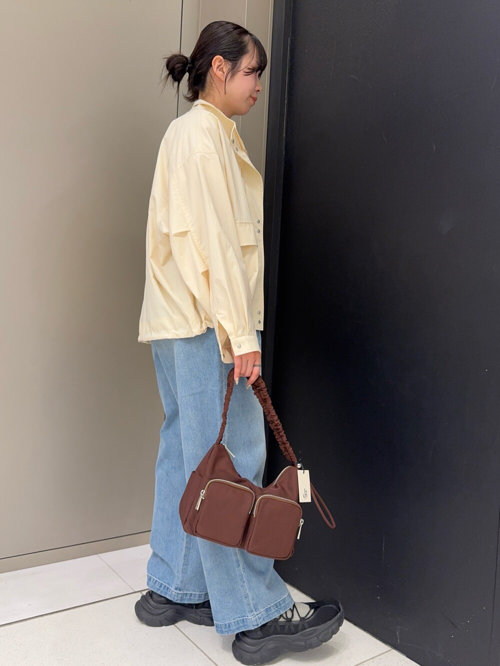 レッド系のTシャツ/カットソー、ホワイト系のブルゾン、ブルー系のデニムパンツを着用したレディースの春コーディネートの3枚目の写真
