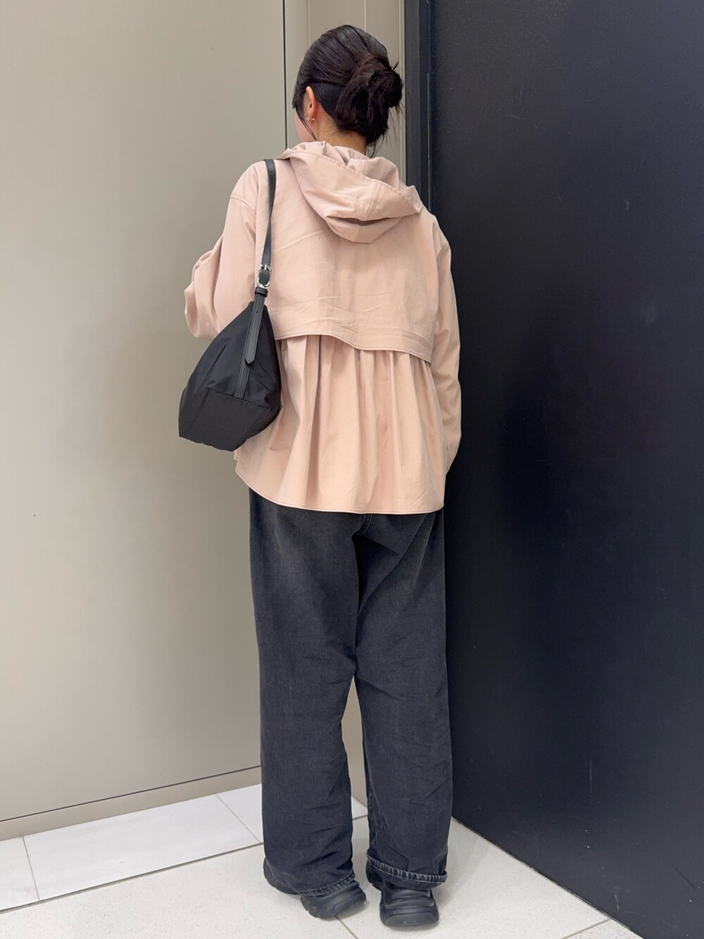ブラック系のデニムパンツ、ブラック系のスニーカー、ベージュ系のその他アウターを着用したレディースの春コーディネートの2枚目の写真