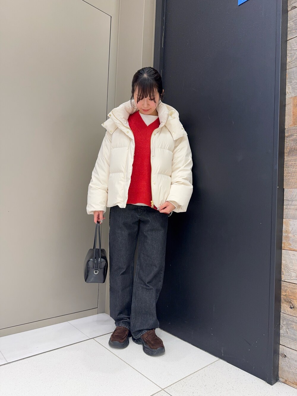 ホワイト系のダウンジャケット/コート、ブラック系のデニムパンツ、ブラウン系のローファーを着用したレディースの冬コーディネートの5枚目の写真
