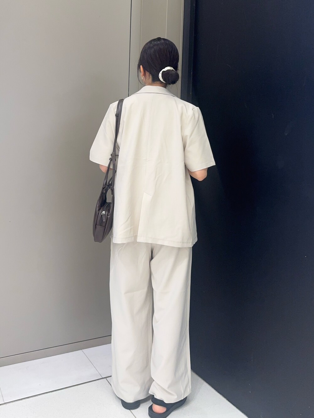 ブラウン系のショルダーバッグ、レッド系のTシャツ/カットソー、ホワイト系のセットアップを着用したレディースの夏コーディネートの3枚目の写真