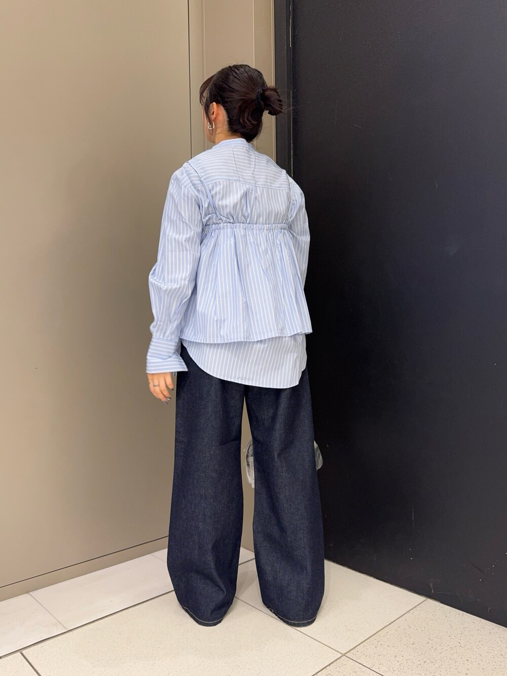 ブルー系のシャツ/ブラウス、シルバー系のボストンバッグ、ブルー系のデニムパンツを着用したレディースの冬コーディネートの5枚目の写真