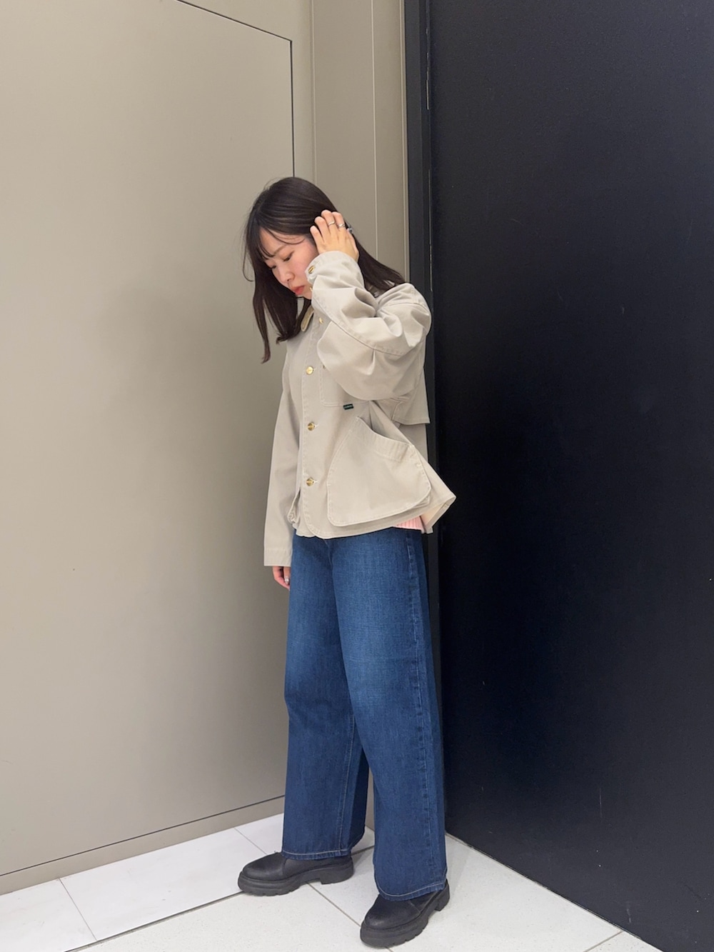 ベージュ系のテーラードジャケット、ブルー系のデニムパンツを着用したレディースの冬コーディネートの3枚目の写真