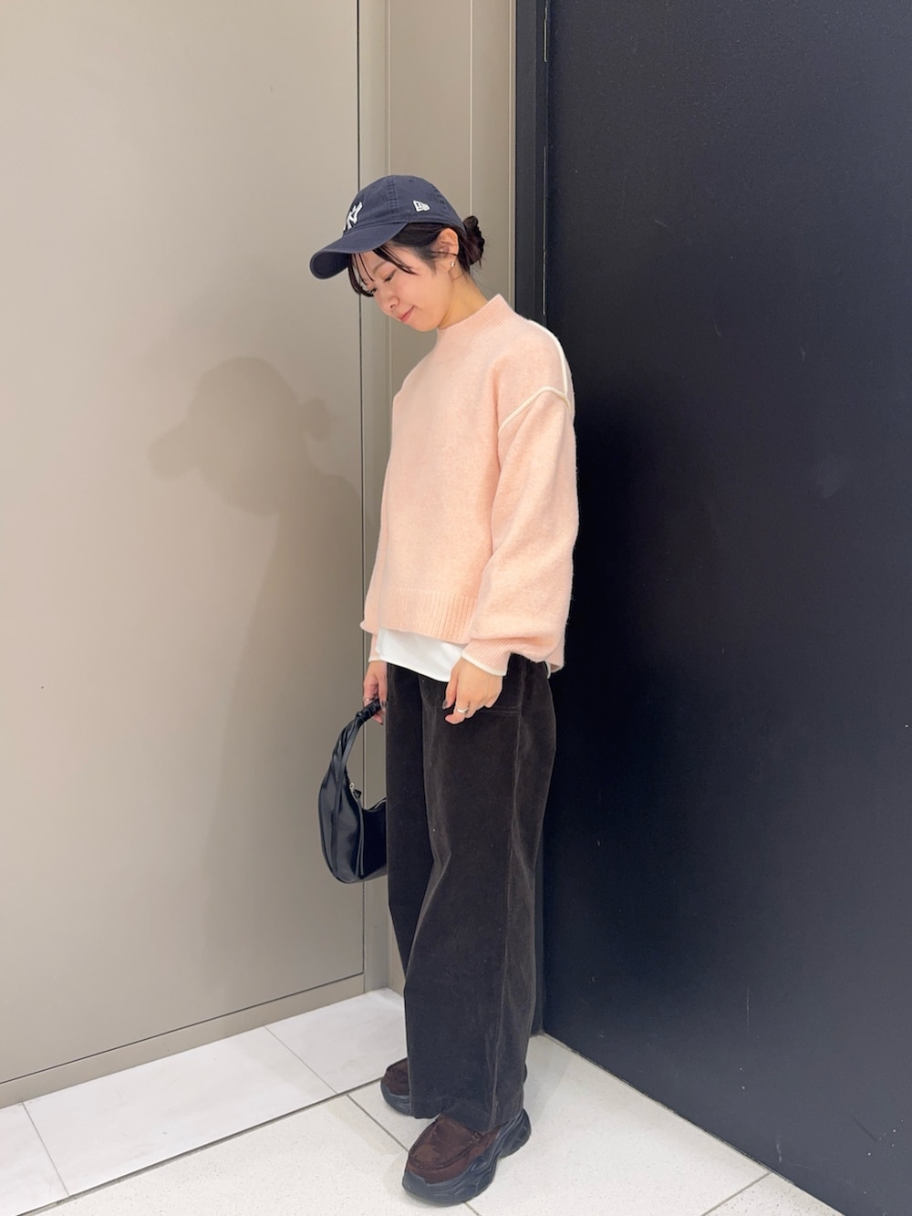 ピンク系のニット/セーター、グレー系のその他パンツ、ブラウン系のローファーを着用したレディースの冬コーディネートの2枚目の写真