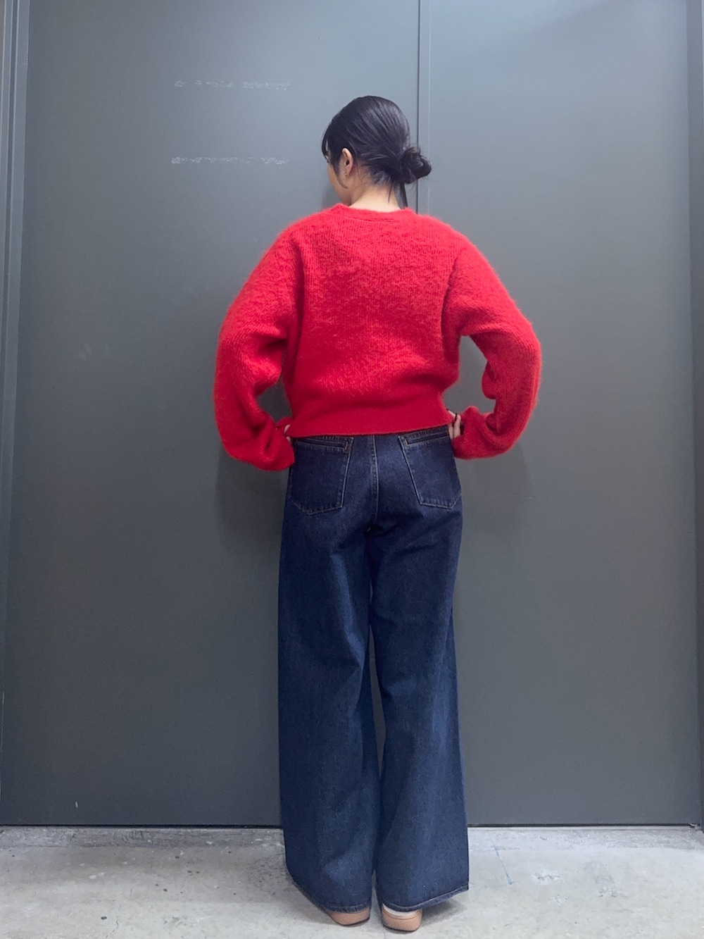 レッド系のカーディガン/ボレロ、ホワイト系のタンクトップ、ブルー系のデニムパンツを着用したレディースの秋コーディネートの2枚目の写真