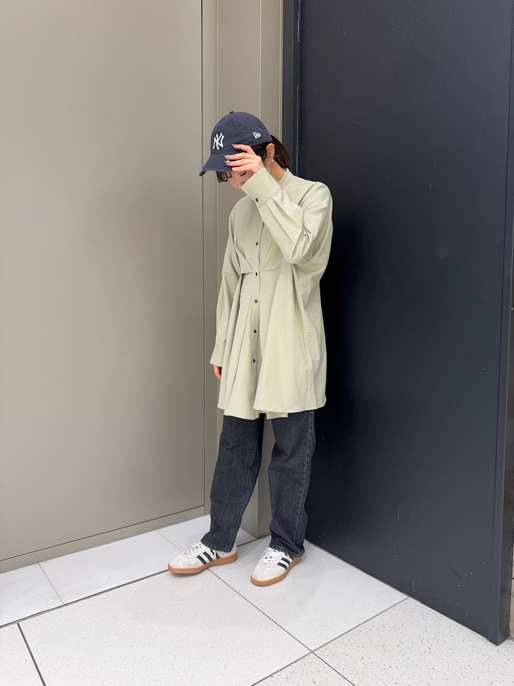 グリーン系のシャツ/ブラウス、ブラック系のデニムパンツを着用したレディースの冬コーディネートの2枚目の写真