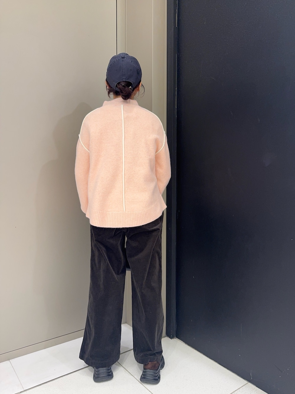 ピンク系のニット/セーター、グレー系のその他パンツ、ブラウン系のローファーを着用したレディースの冬コーディネートの3枚目の写真