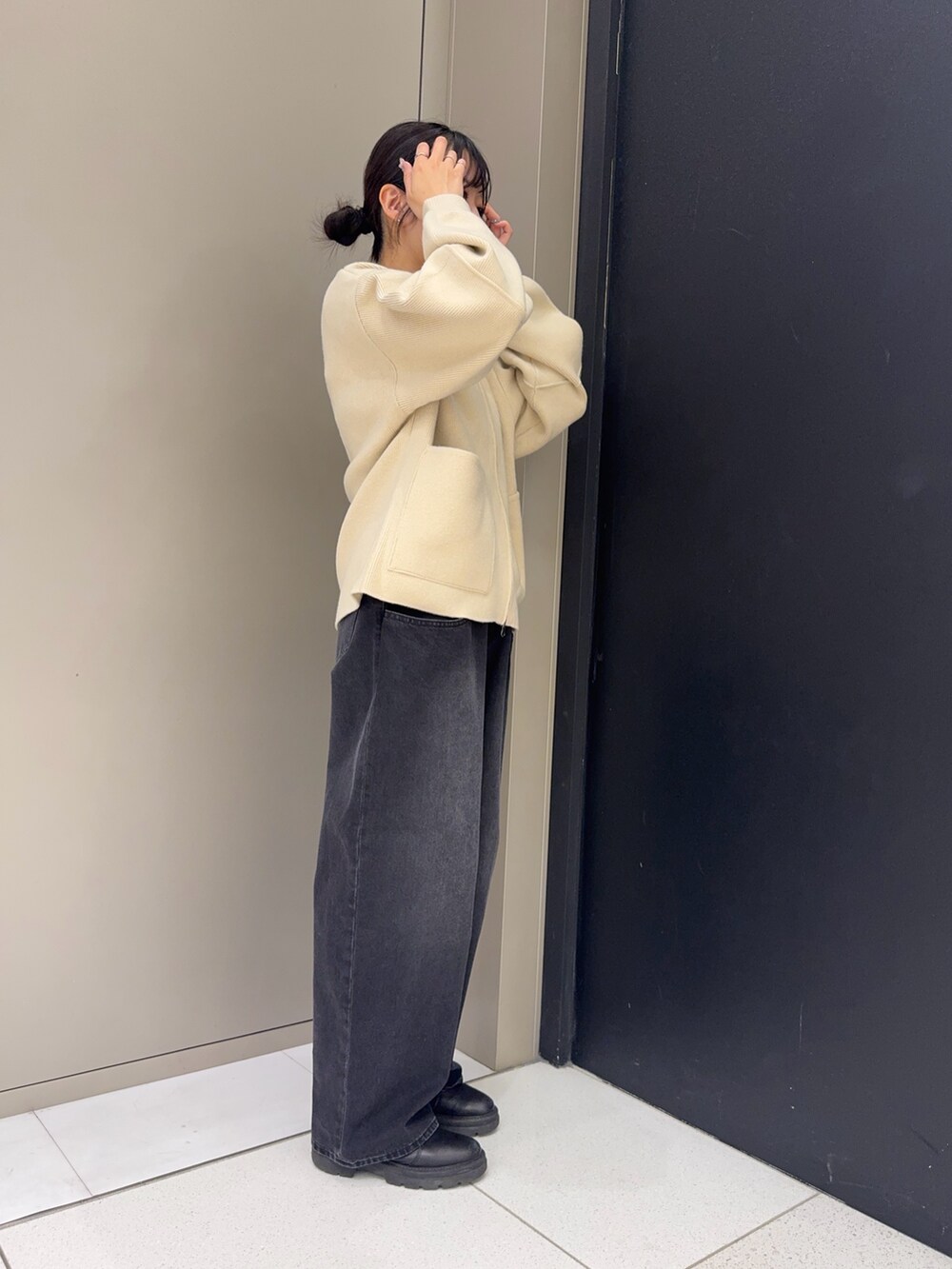 ホワイト系のシャツ/ブラウス、ブラック系のデニムパンツ、ベージュ系のニット/セーターを着用したレディースの冬コーディネートの2枚目の写真