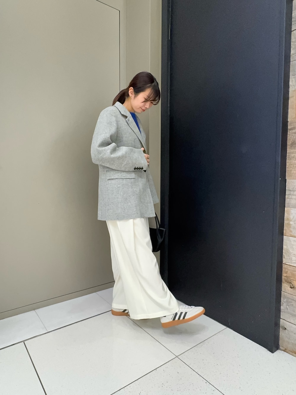 グレー系のその他アウター、ブルー系のニット/セーター、ホワイト系のその他パンツを着用したレディースの冬コーディネートの2枚目の写真