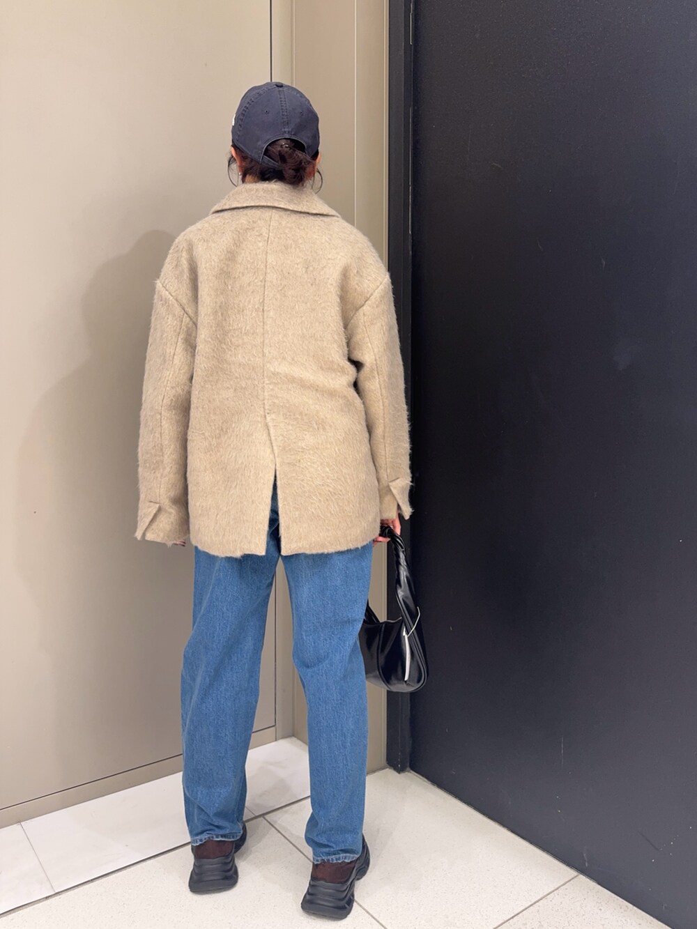 ブラウン系のその他アウター、ブルー系のデニムパンツ、ブラウン系のローファーを着用したレディースの冬コーディネートの3枚目の写真