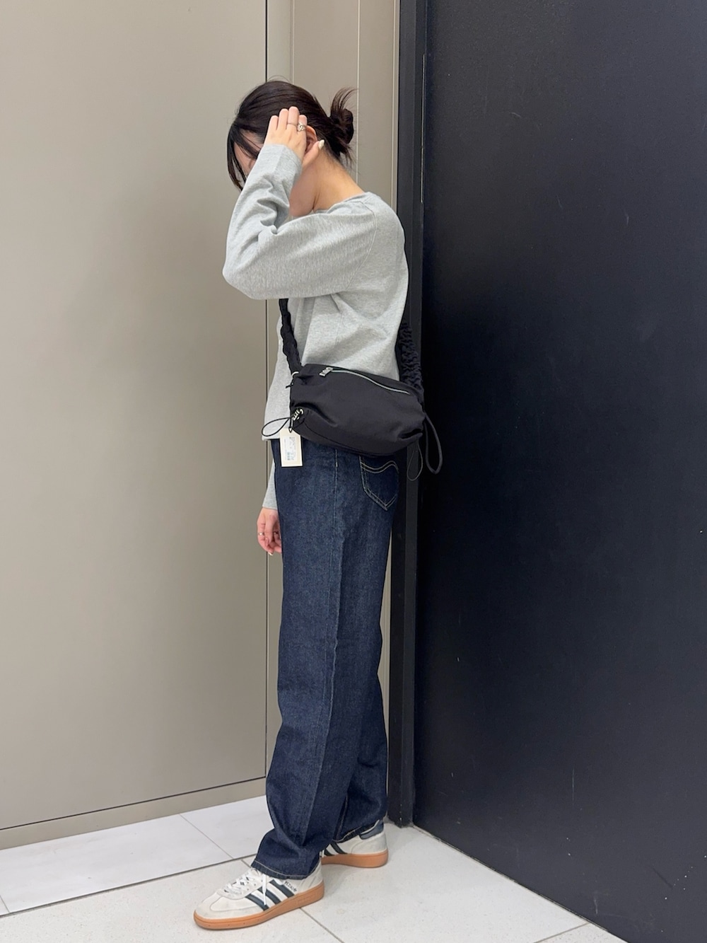 グレー系のカーディガン/ボレロ、ブルー系のデニムパンツ、ホワイト系のスニーカーを着用したレディースの春コーディネートの2枚目の写真