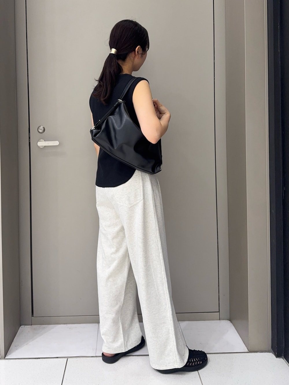 ホワイト系のその他パンツ、ブラック系のサンダル、ブラック系のショルダーバッグを着用したレディースの夏コーディネートの3枚目の写真