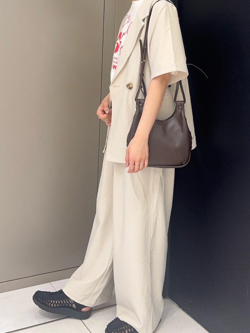 ブラウン系のショルダーバッグ、レッド系のTシャツ/カットソー、ホワイト系のセットアップを着用したレディースの夏コーディネートの2枚目の写真