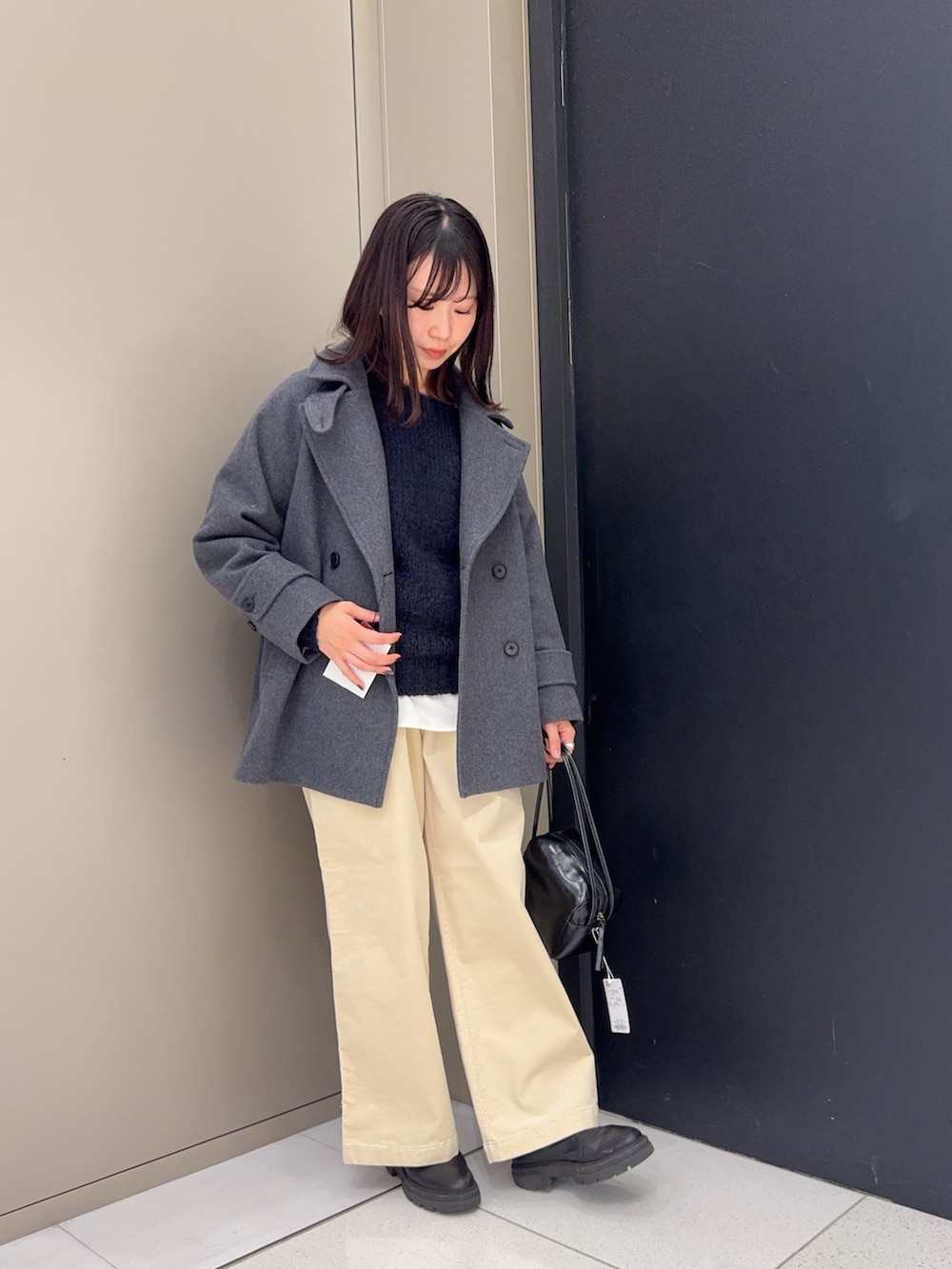 グレー系のピーコートを着用したレディースの冬コーディネートの3枚目の写真