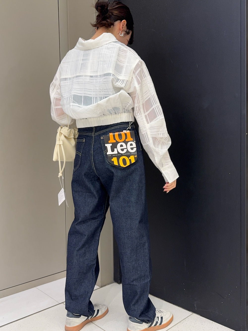 ブルー系のタンクトップ、ホワイト系のシャツ/ブラウス、ブルー系のデニムパンツを着用したレディースの春コーディネートの3枚目の写真