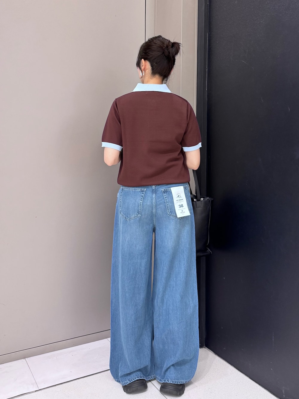ブラウン系のニット/セーター、ブルー系のデニムパンツ、ブラック系のトートバッグを着用したレディースの春コーディネートの3枚目の写真