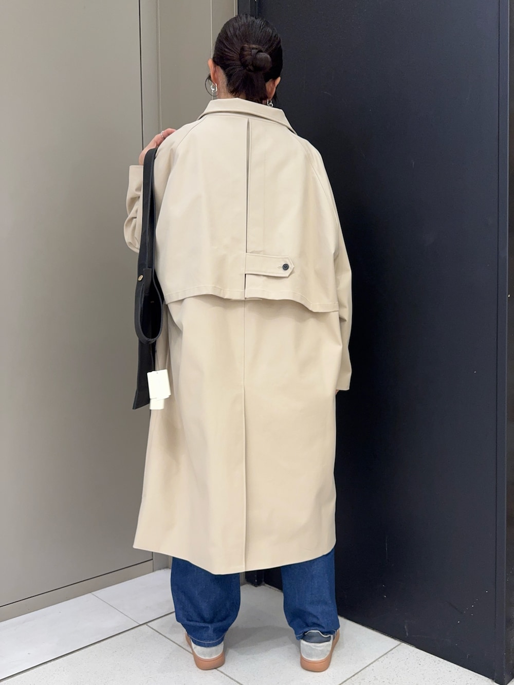 ベージュ系のその他アウター、レッド系のTシャツ/カットソー、ブルー系のデニムパンツを着用したレディースの春コーディネートの2枚目の写真