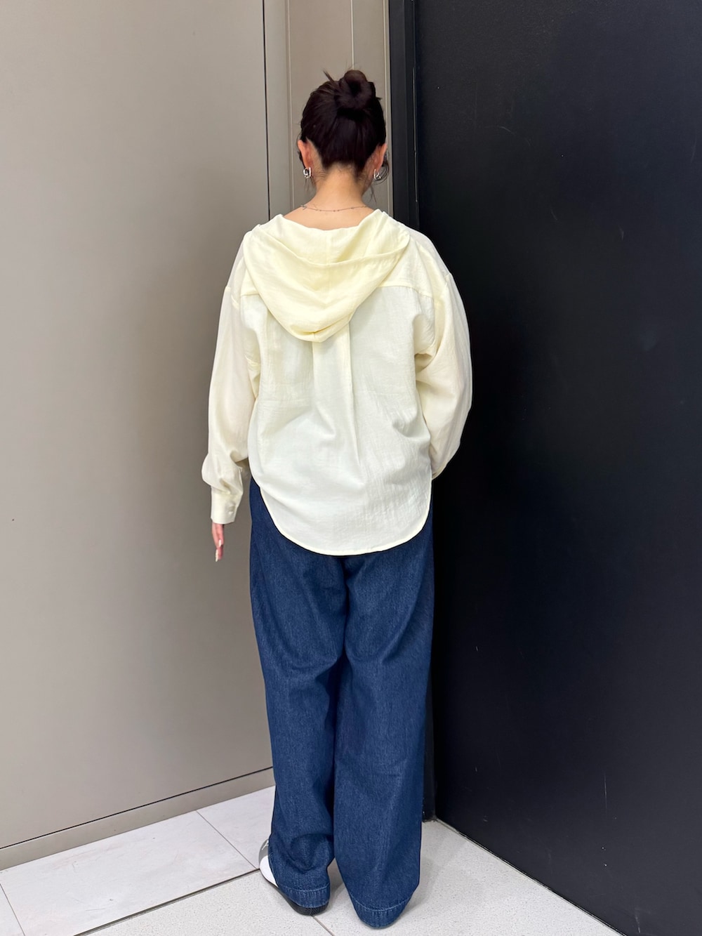 ホワイト系のシャツ/ブラウス、ブルー系のデニムパンツ、シルバー系のスニーカーを着用したレディースの春コーディネートの3枚目の写真