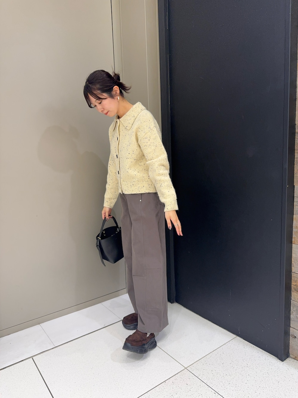 ベージュ系のカーディガン/ボレロ、グレー系のその他パンツ、ブラウン系のローファーを着用したレディースの冬コーディネートの3枚目の写真