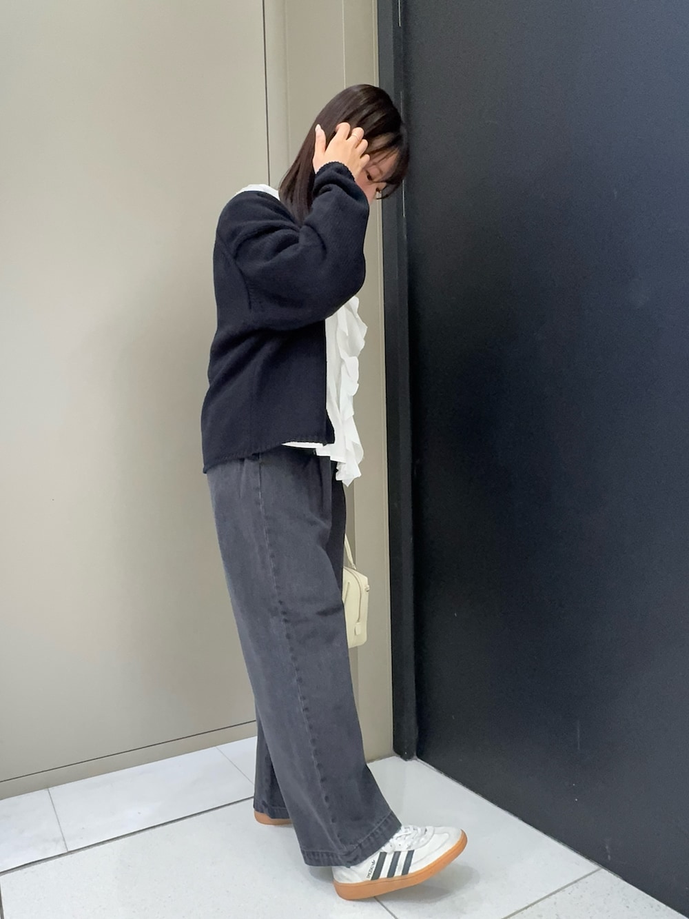 ブラック系のカーディガン/ボレロ、ホワイト系のシャツ/ブラウス、ホワイト系のボストンバッグを着用したレディースの春コーディネートの3枚目の写真