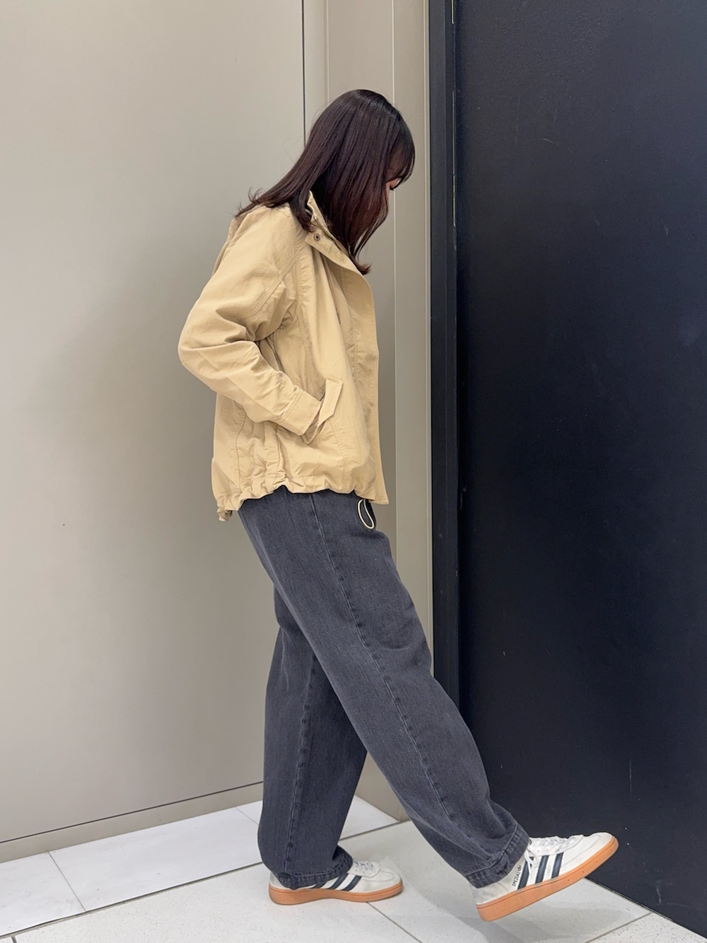 ベージュ系のナイロンジャケット、ブルー系のTシャツ/カットソー、ブラック系のデニムパンツを着用したレディースの春コーディネートの2枚目の写真