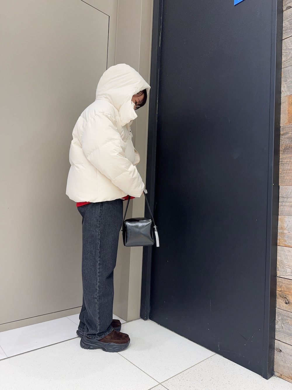 ホワイト系のダウンジャケット/コート、ブラック系のデニムパンツ、ブラウン系のローファーを着用したレディースの冬コーディネートの2枚目の写真