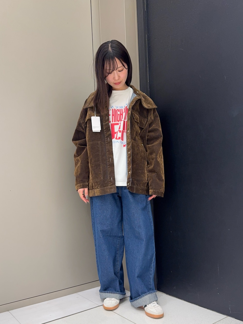 ブラウン系のブルゾン、ホワイト系のTシャツ/カットソー、ブルー系のデニムパンツを着用したレディースの冬コーディネートの3枚目の写真