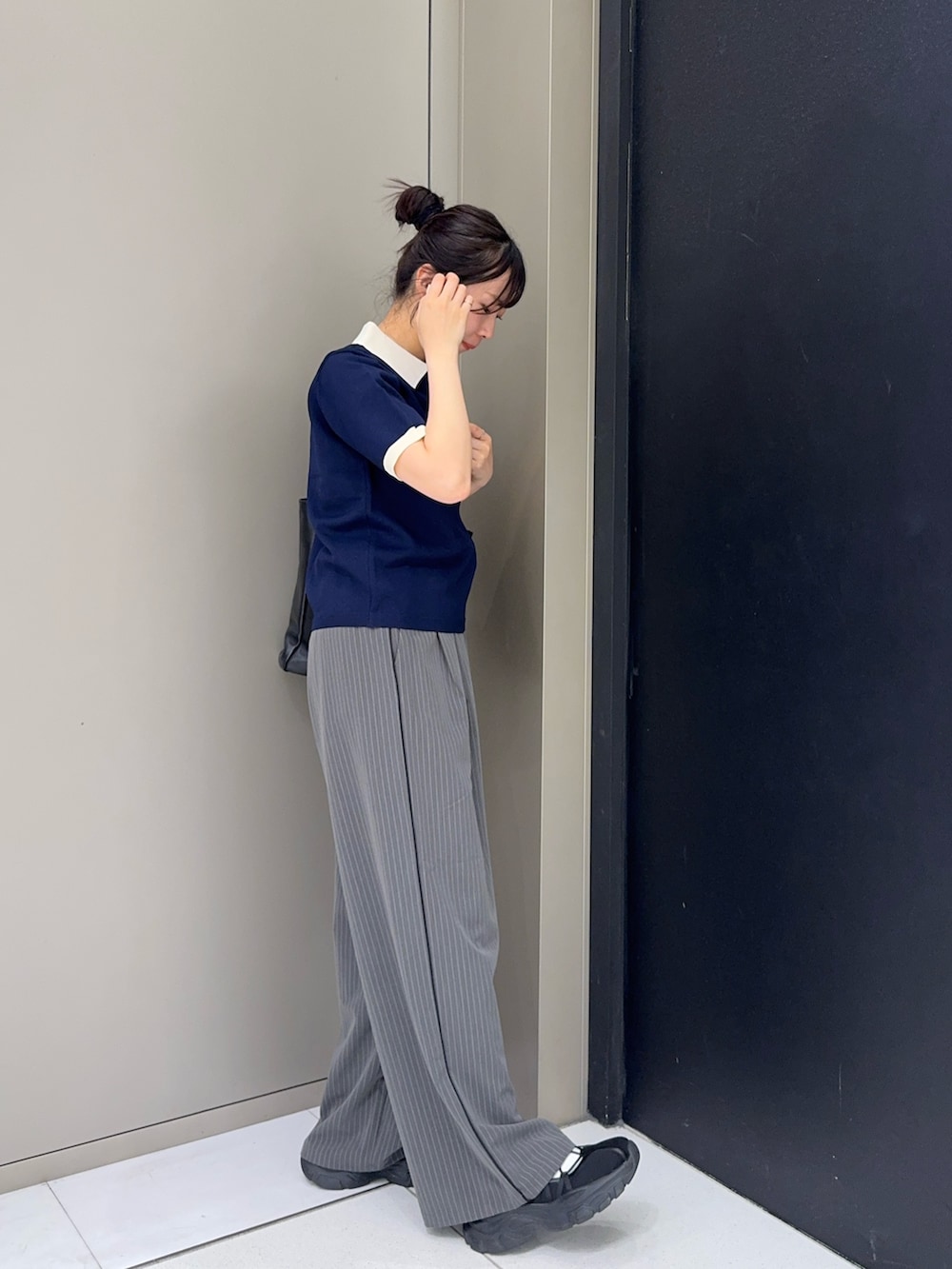 ブルー系のニット/セーター、グレー系のその他パンツ、ブラック系のスニーカーを着用したレディースの春コーディネートの3枚目の写真