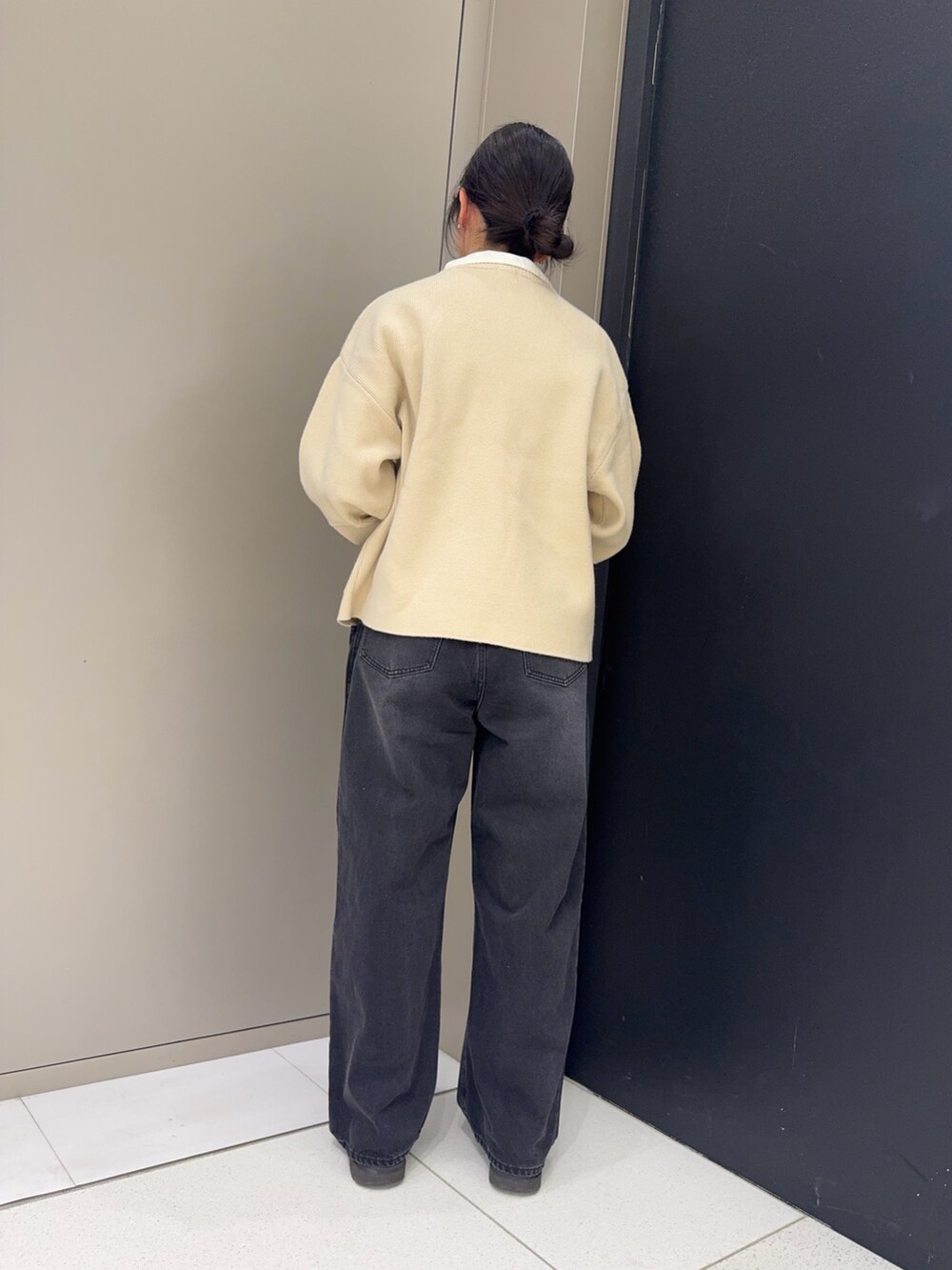 ホワイト系のシャツ/ブラウス、ブラック系のデニムパンツ、ベージュ系のニット/セーターを着用したレディースの冬コーディネートの3枚目の写真