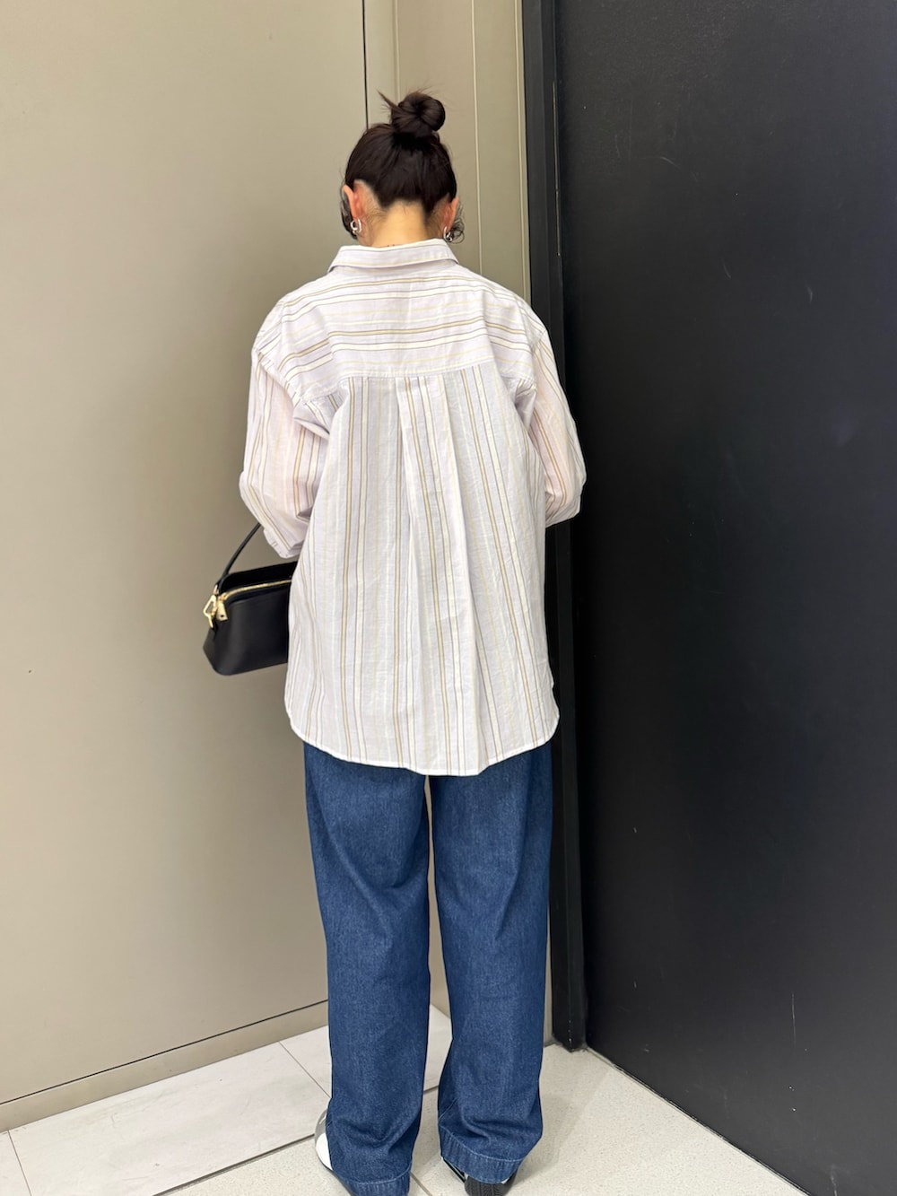ブラック系のショルダーバッグ、パープル系のシャツ/ブラウス、ブルー系のデニムパンツを着用したレディースの春コーディネートの3枚目の写真