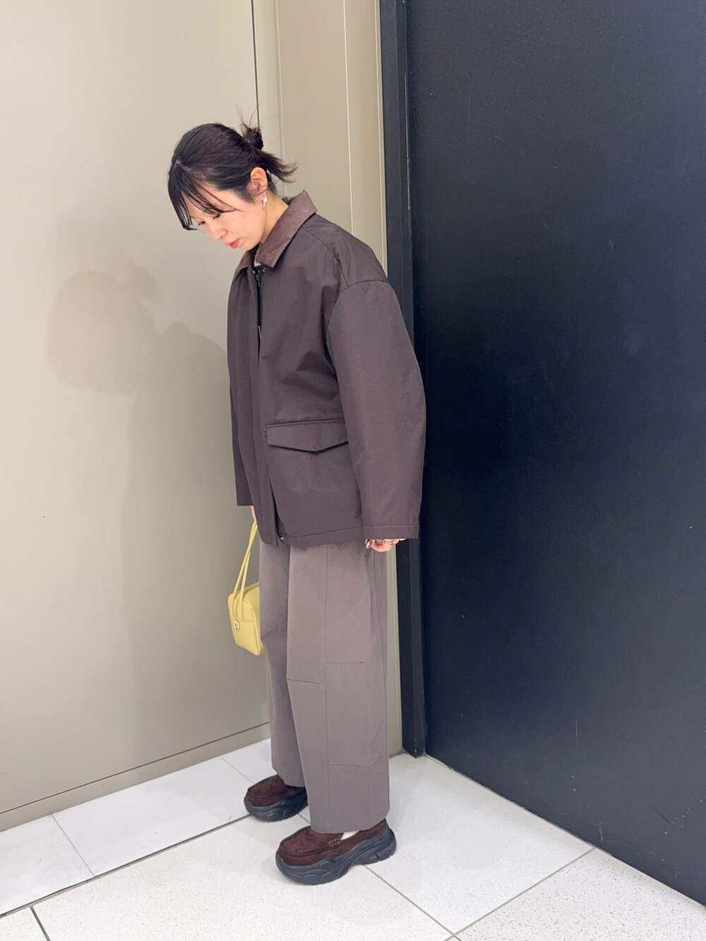 ブラウン系のダウンジャケット/コート、ベージュ系のショルダーバッグ、グレー系のその他パンツを着用したレディースの冬コーディネートの2枚目の写真