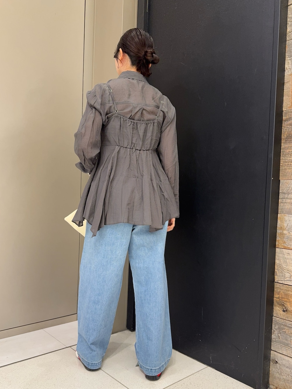 グレー系のシャツ/ブラウス、ホワイト系のショルダーバッグ、ブルー系のデニムパンツを着用したレディースの春コーディネートの2枚目の写真