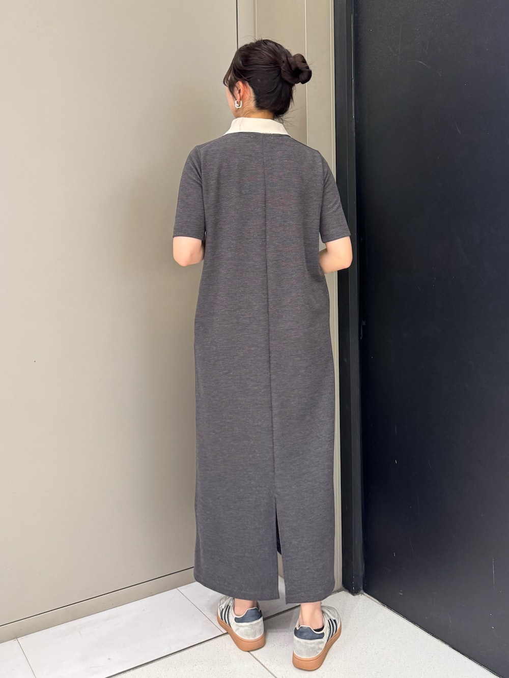 グレー系のワンピース、ホワイト系のショルダーバッグ、ホワイト系のスニーカーを着用したレディースの春コーディネートの2枚目の写真
