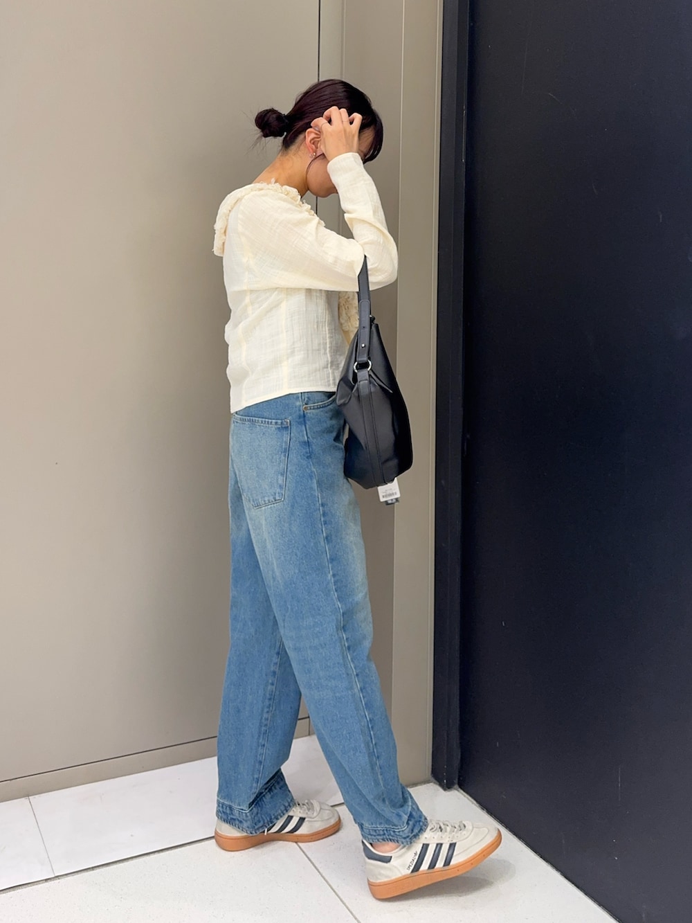 ホワイト系のシャツ/ブラウス、ブルー系のデニムパンツ、ホワイト系のスニーカーを着用したレディースの秋コーディネートの2枚目の写真