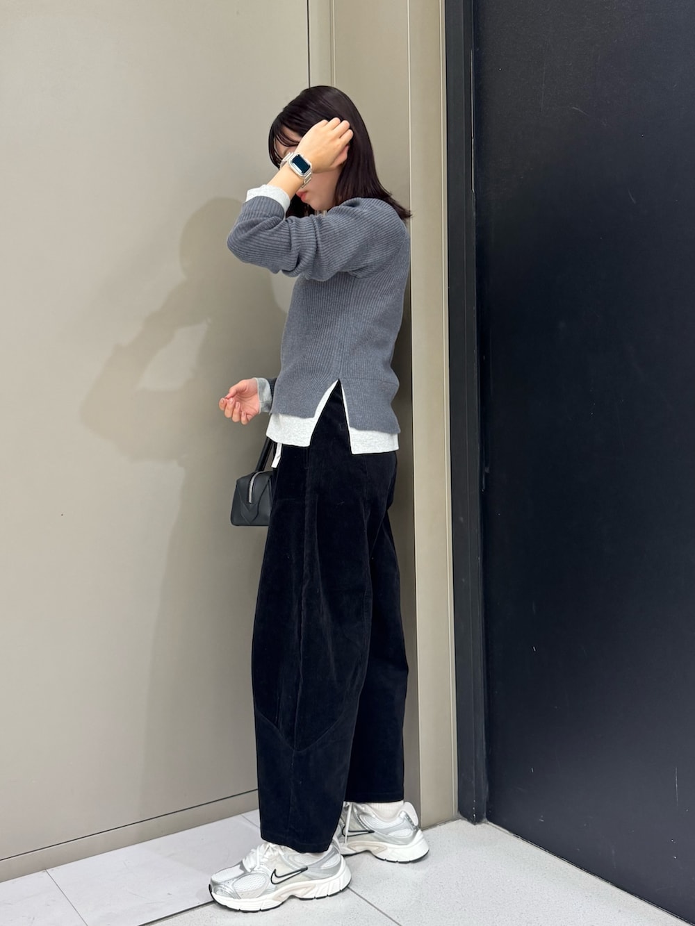 グレー系のニット/セーター、ブラック系のハンドバッグ、ブラック系のその他パンツを着用したレディースの秋コーディネートの3枚目の写真